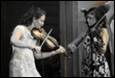 A person playing violin with another person

Description automatically generated
