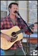 A person playing guitar and singing

Description automatically generated