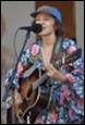 A person singing into a microphone and playing guitar

Description automatically generated