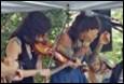 A group of people playing a violin

Description automatically generated