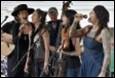 A group of people singing and playing instruments

Description automatically generated
