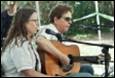 A person and person playing guitar

Description automatically generated