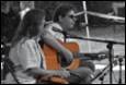 A person and person playing guitar

Description automatically generated