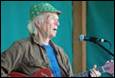 A person with a guitar in front of a microphone

Description automatically generated with low confidence