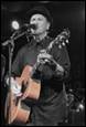 A person playing guitar and singing into a microphone

Description automatically generated with low confidence