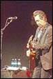 A person playing a guitar on a stage

Description automatically generated with medium confidence