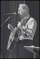 A person playing guitar in front of a microphone

Description automatically generated with medium confidence