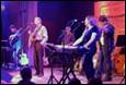 A group of people playing instruments on a stage

Description automatically generated with medium confidence