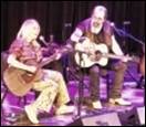 A person and person playing guitars on stage

Description automatically generated