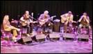 A group of people playing guitars

Description automatically generated